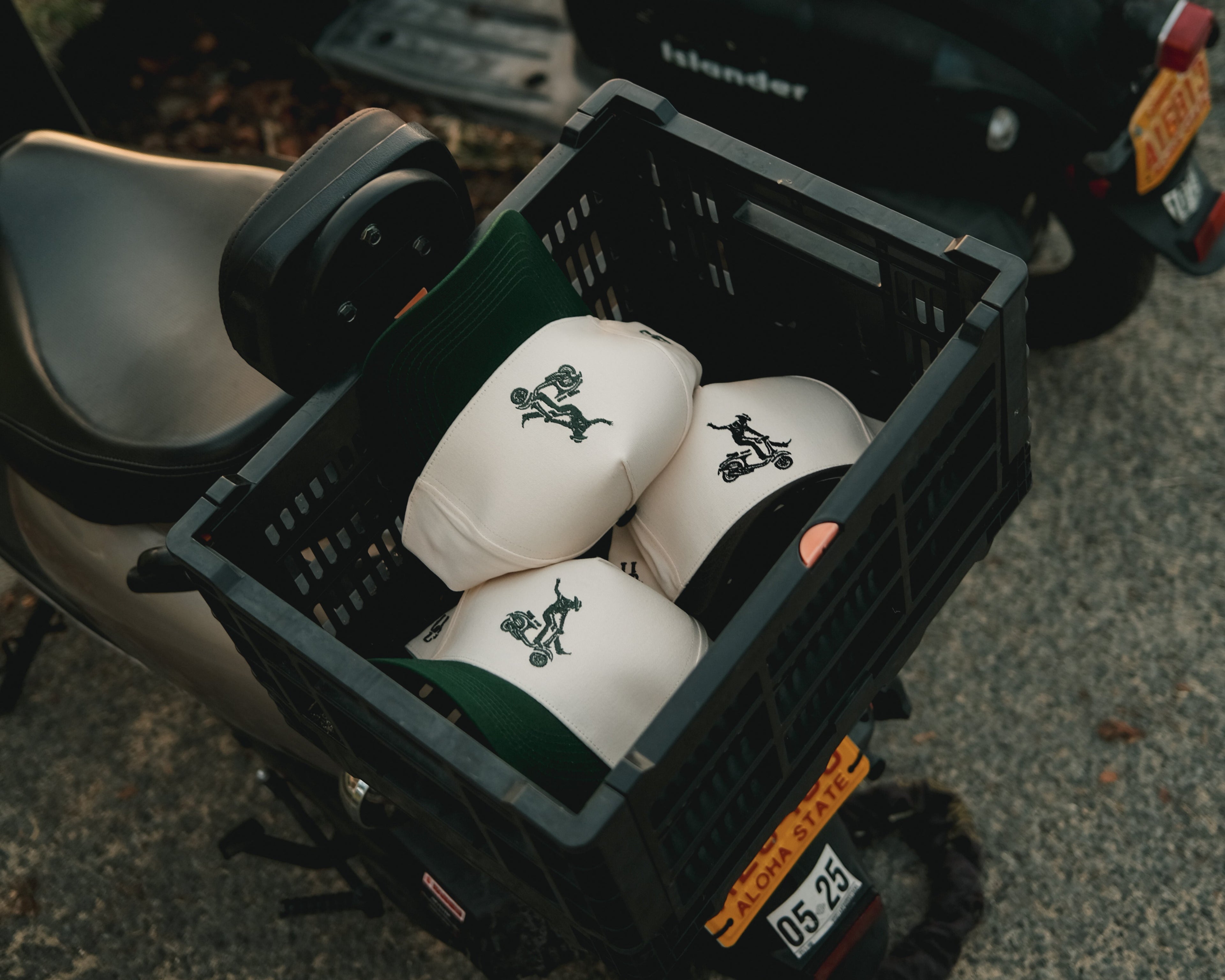 Urban Cowboy hats in moped crate with green and black brims and Western logos
